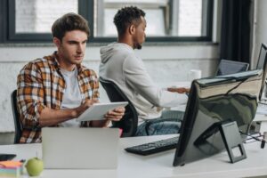 men work in office on multiple devices enabled by Intune