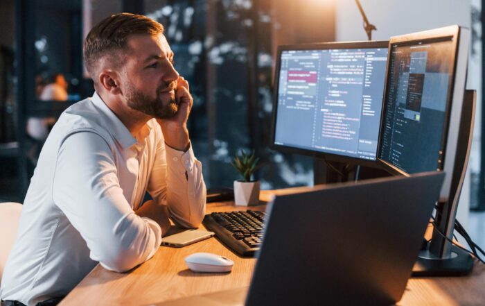IT person in office with multiple screens