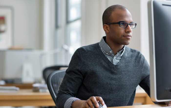 Young business man working on computer in office with Copilot