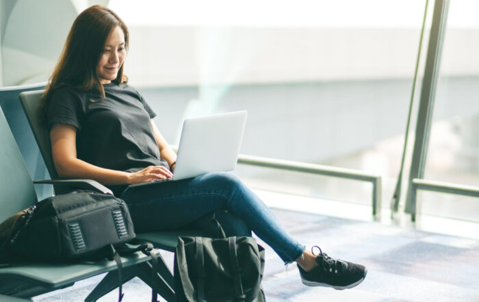 A woman traveler using laptop computer while sitting in the airport